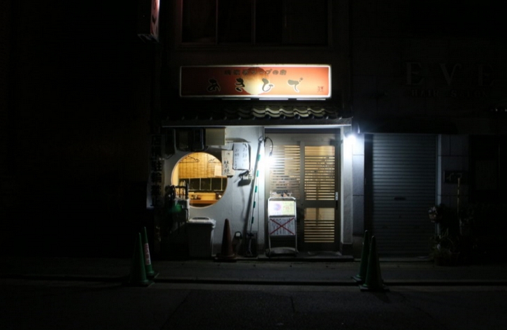 京都の薄暗い夜にぼんやり光るラーメン店「亜喜英（あきひで）」