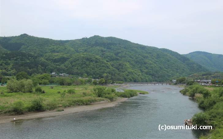 京都の嵐山、桂川が流れる先に渡月橋が見え、奥は日本海まで山が続きます