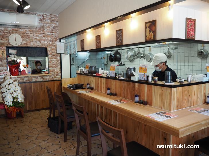 L字カウンターと厨房、テーブル席もある店内